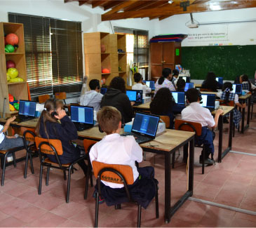 Foto de Niños aprendiendo en la sala de computadoras de FBC