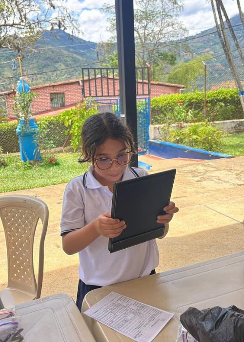 Niña leyendo Niño pulgar arriba jornada de salud visual escuela el noral